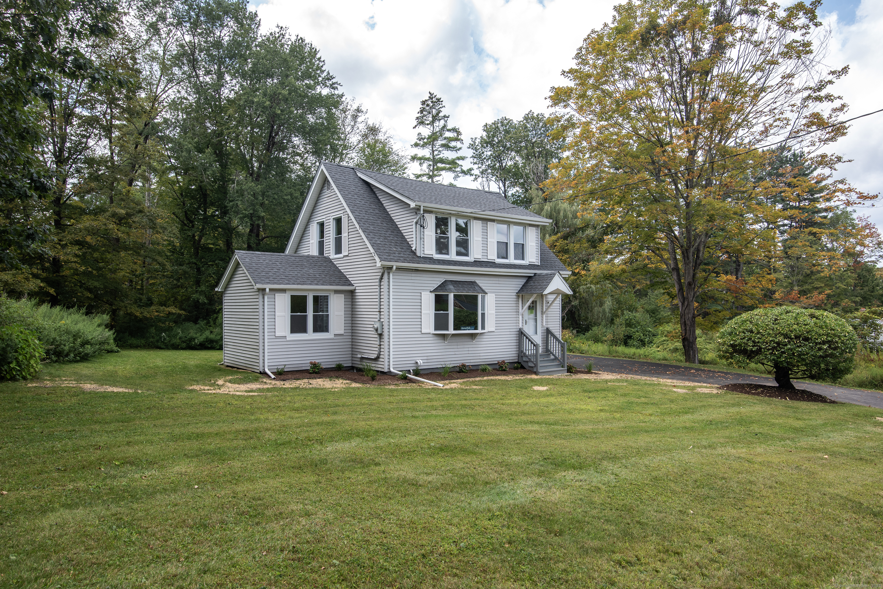 260 Hayden Hill Road Torrington, CT 06790 - Photo 3 of 18 a house that is sitting in the grass with large trees and plants