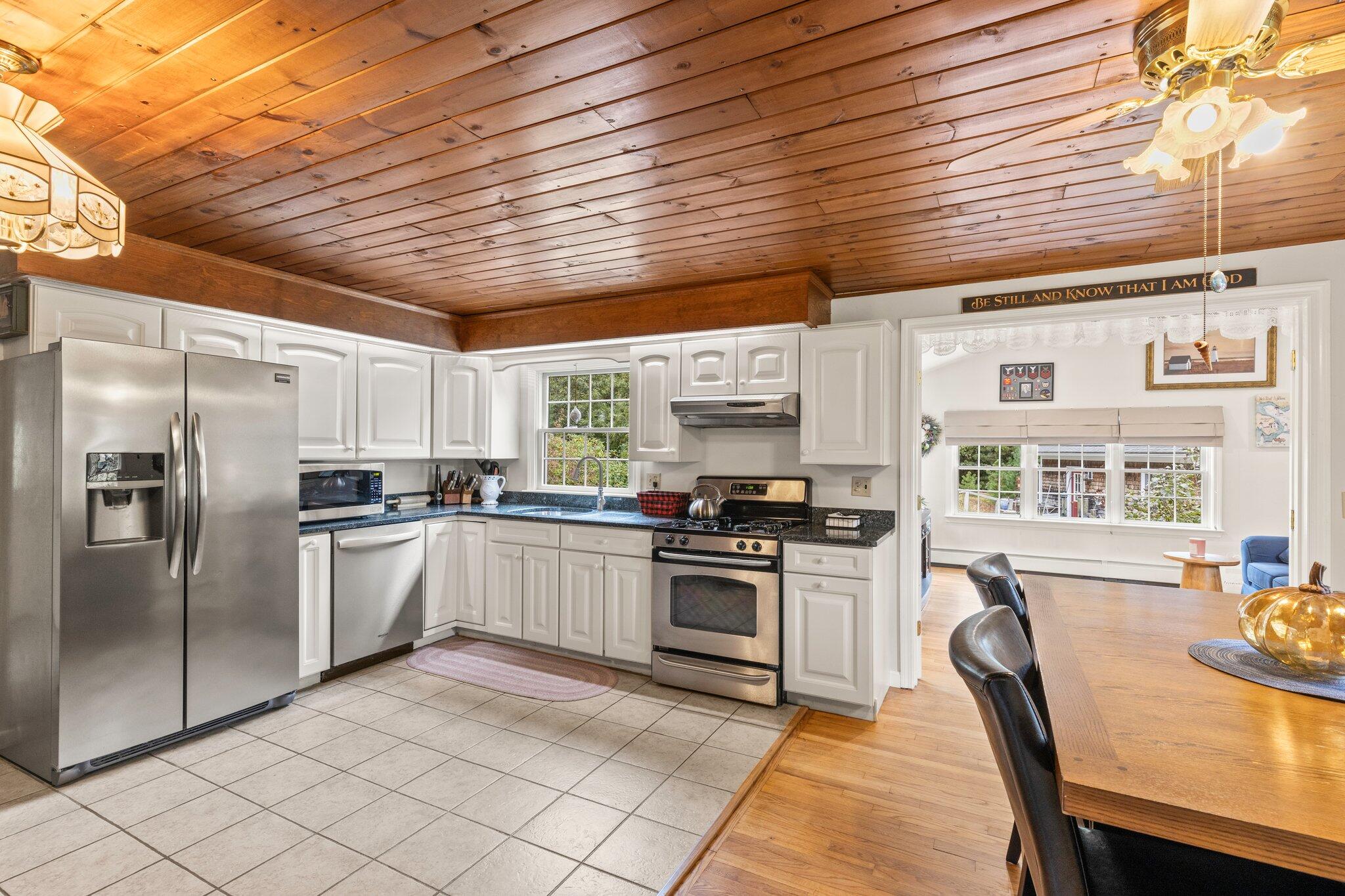 3 Fathom Lane Wareham, MA 02571 - Photo 7 of 57 a kitchen with stainless steel appliances granite countertop a stove top oven a sink dishwasher a dining table and chairs with wooden floor