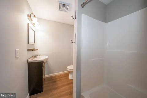 a bathroom with a sink a toilet and shower