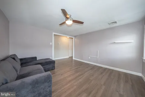 a living room with furniture and a ceiling fan