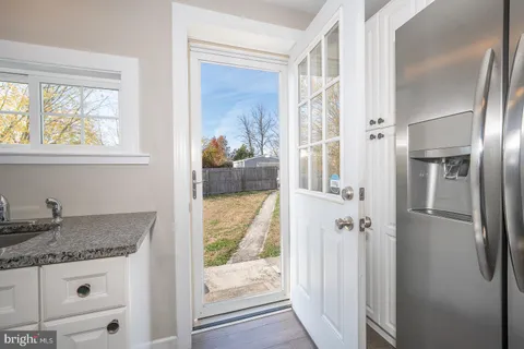 a bathroom with a granite countertop sink a mirror and shower