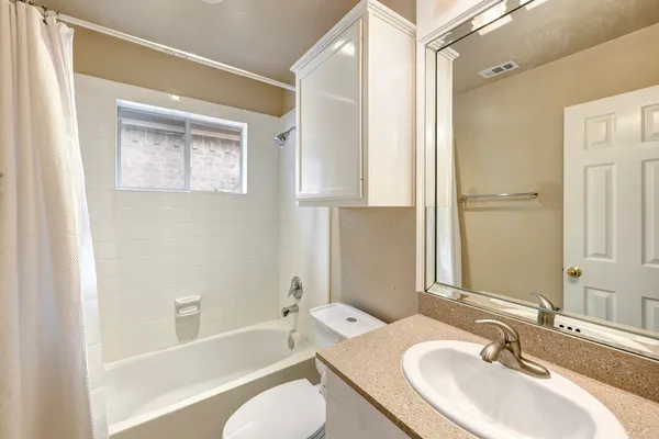 a bathroom with a granite countertop sink toilet and shower