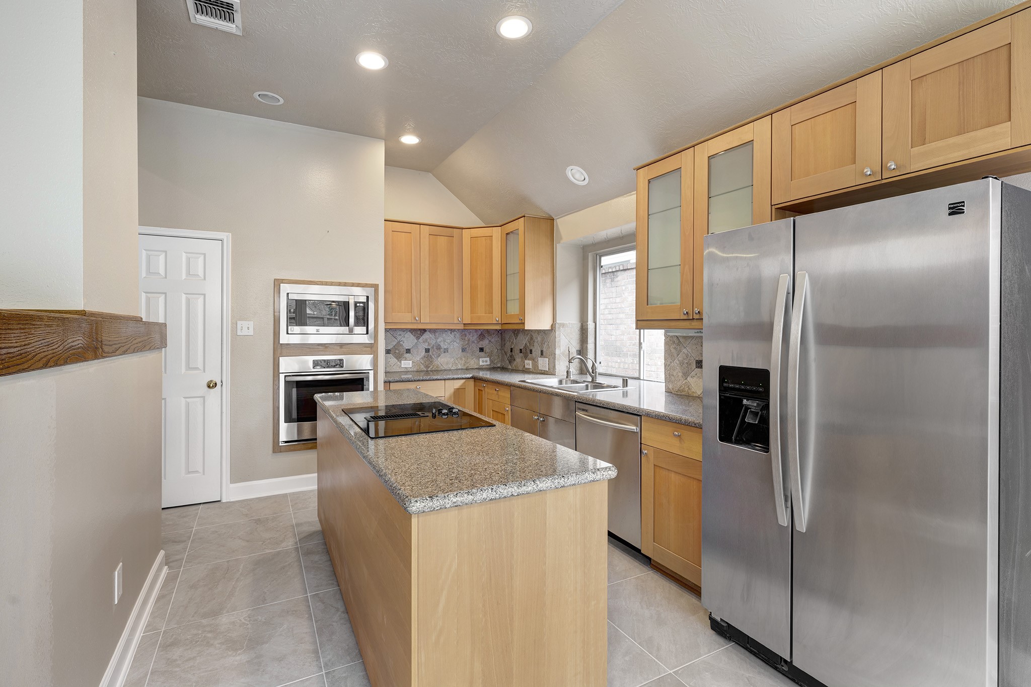 7019 Lawler Ridge Houston, TX 77055 - Photo 7 of 18 a kitchen with granite countertop stainless steel appliances a refrigerator a stove top oven and sink