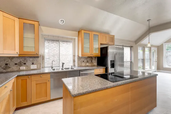 a kitchen with sink a window and cabinets