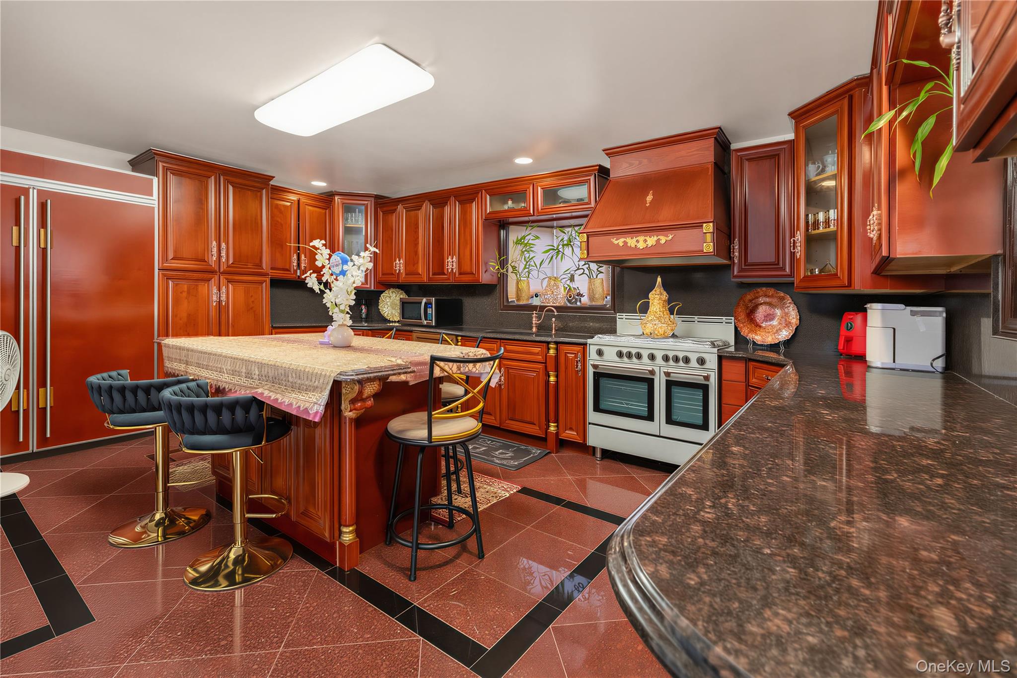 265-04 79th Avenue Queens, NY 11004 - Photo 16 of 22 a kitchen with stainless steel appliances granite countertop a stove top oven a sink and cabinets