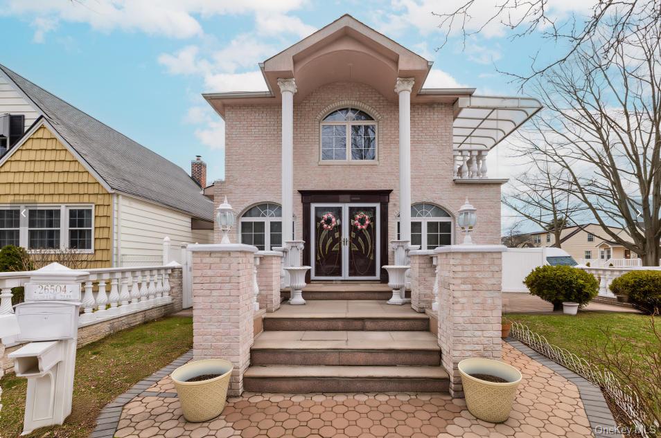 265-04 79th Avenue Queens, NY 11004 - Photo 2 of 22 a front view of a house with a garden and plants