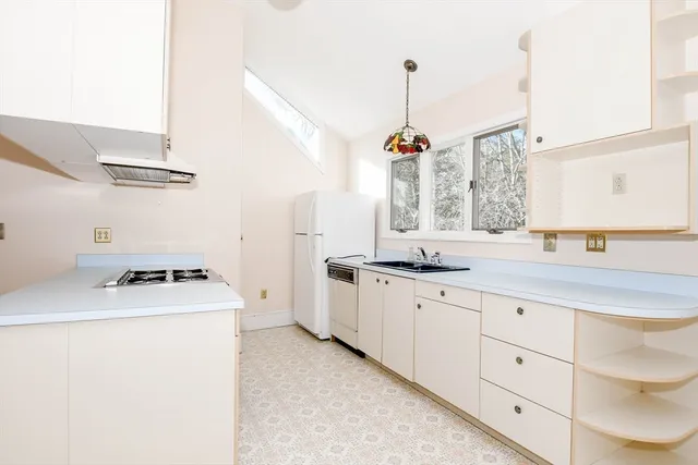 a view of a white house with a large tree