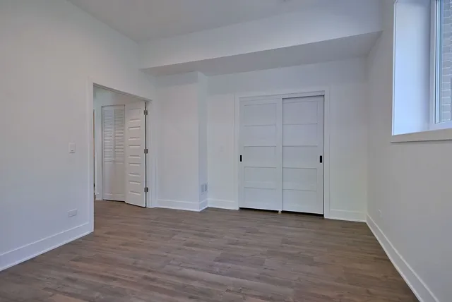 a view of empty room with wooden floor