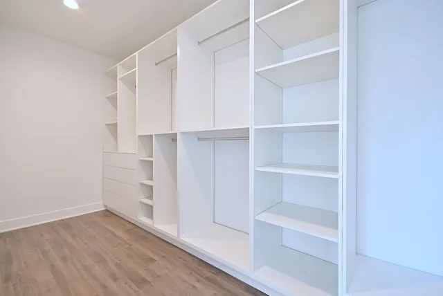 a view of walk in closet with empty racks