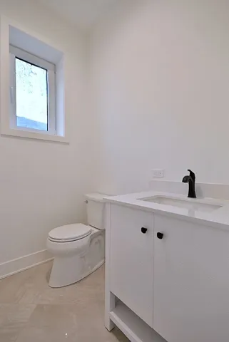 a bathroom with a toilet a sink a vanity and mirror
