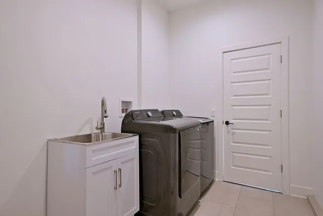 a utility room with sink dryer and washer