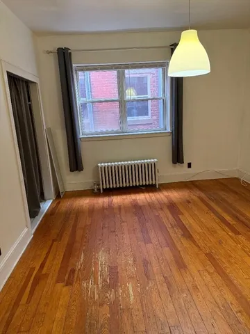 a view of a room with wooden floor and a window
