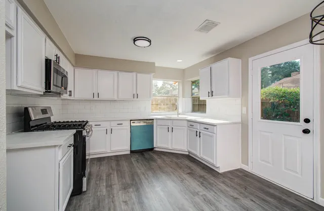 a view of a kitchen with wooden floor and a kitchen