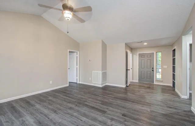 a view of an empty room with chandelier and fireplace