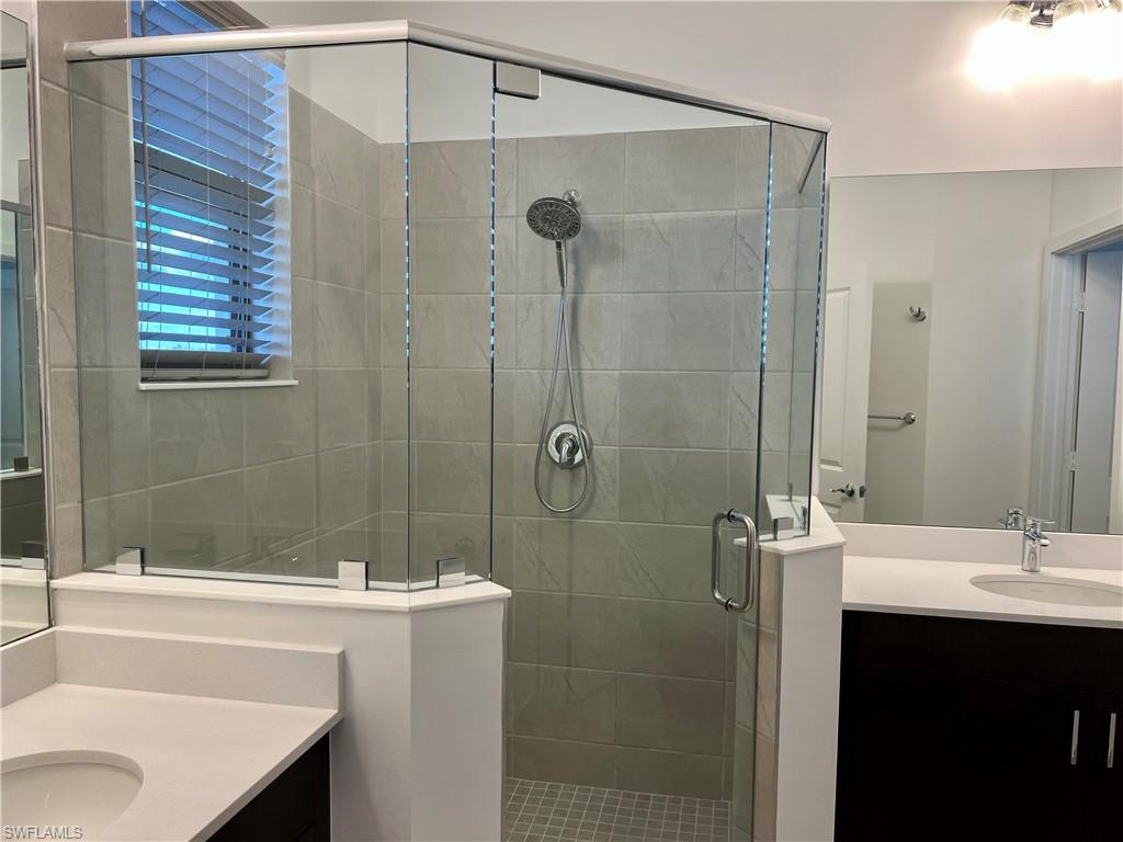 5653 Cerva Lane Ave Maria, FL 34142 - Photo 14 of 24 a bathroom with a sink a mirror and a bathtub