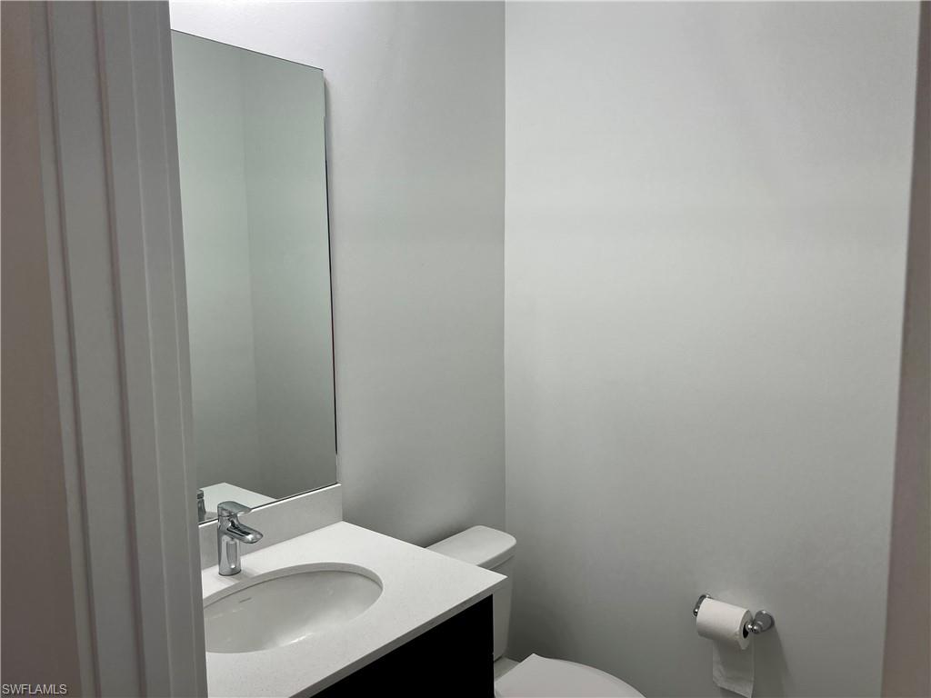 5653 Cerva Lane Ave Maria, FL 34142 - Photo 17 of 24 a bathroom with a sink a toilet and a mirror