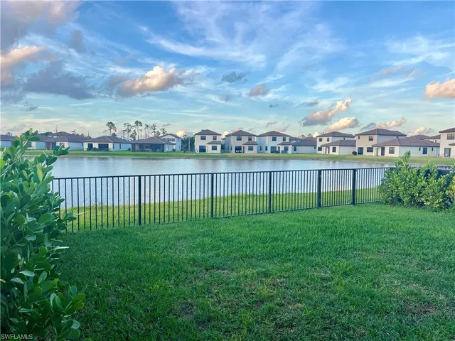 a view of an empty room with kitchen and a window