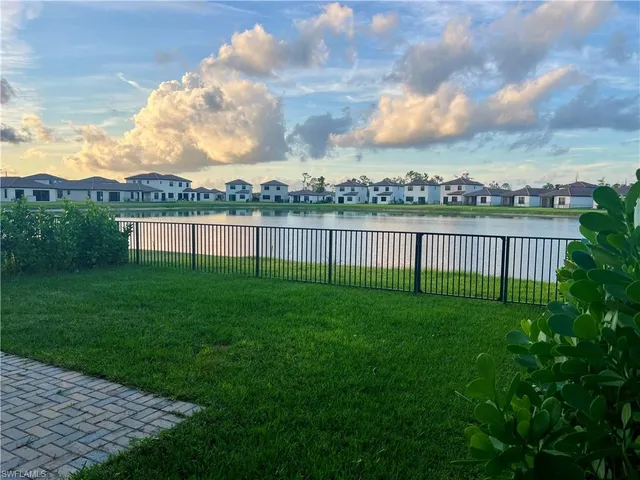 a large kitchen with stainless steel appliances a large counter top and a refrigerator