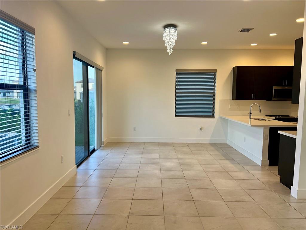 5653 Cerva Lane Ave Maria, FL 34142 - Photo 6 of 24 a view of an empty room with kitchen and a window