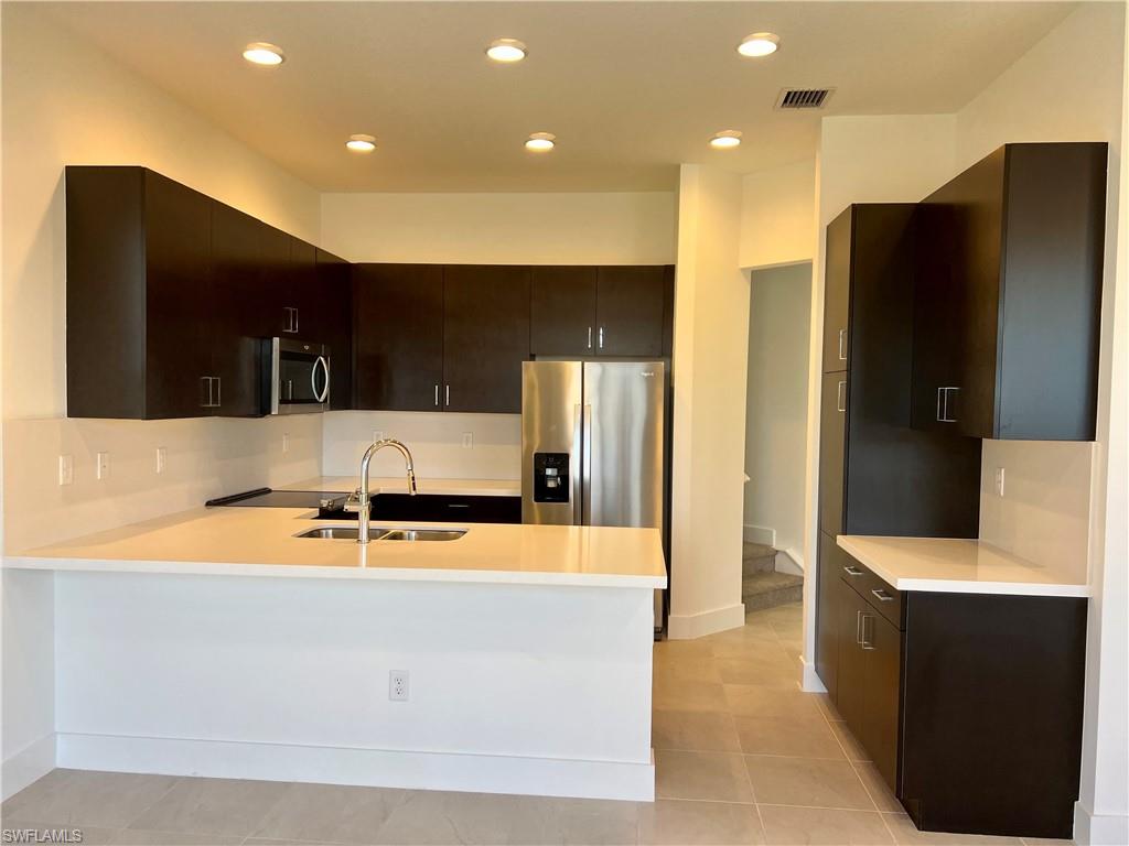 5653 Cerva Lane Ave Maria, FL 34142 - Photo 7 of 24 a large kitchen with stainless steel appliances a large counter top and a refrigerator