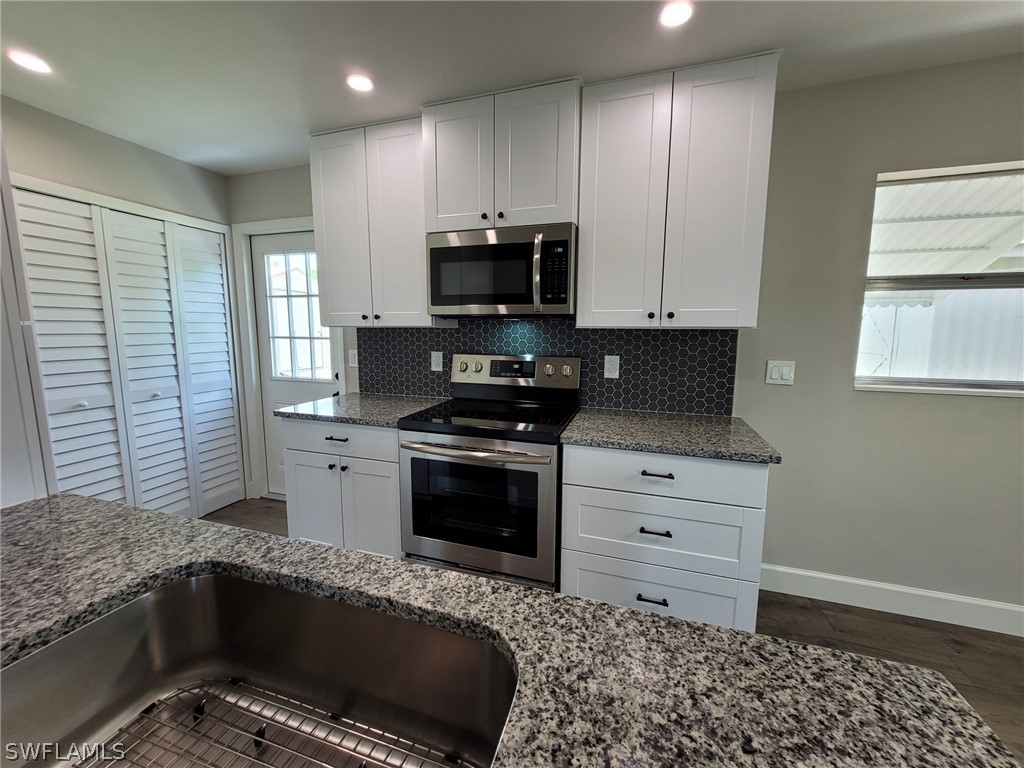 105 Alabama Road South Lehigh Acres, FL 33936 - Photo 15 of 25 a kitchen with a sink and a stove top oven