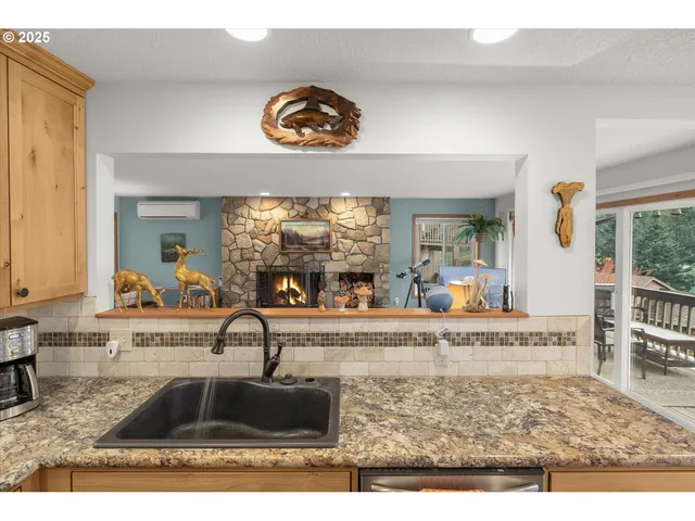 a kitchen with stainless steel appliances granite countertop a stove a sink dishwasher and white cabinets with wooden floor