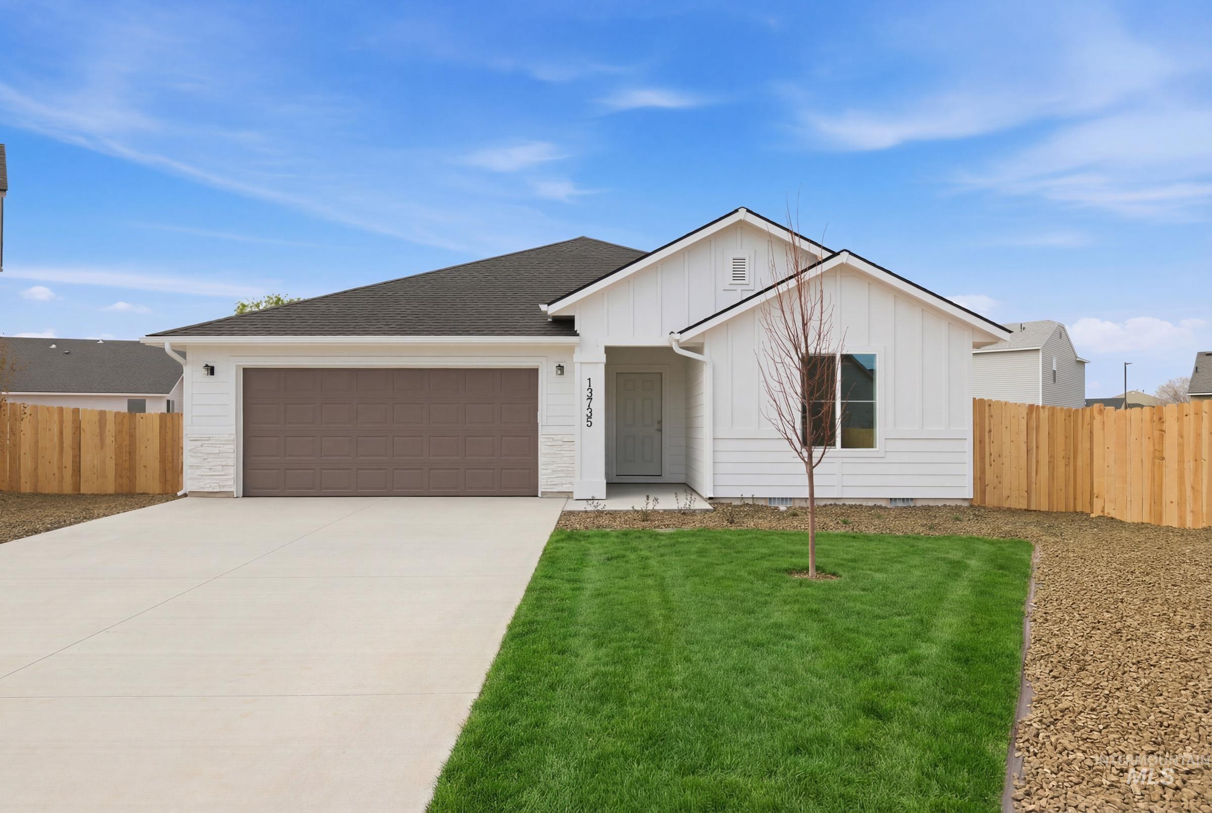 13735 Inman Court Caldwell, ID 83607 - Photo 1 of 20 View of front of property featuring an attached garage, board and batten siding, driveway, and a shingled roof