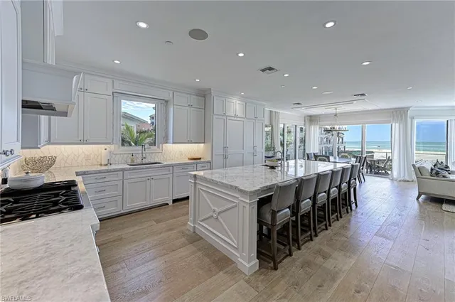 a large kitchen with kitchen island a stove a sink a dining table and chairs