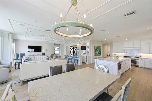 a large kitchen with kitchen island a stove a sink a dining table and chairs