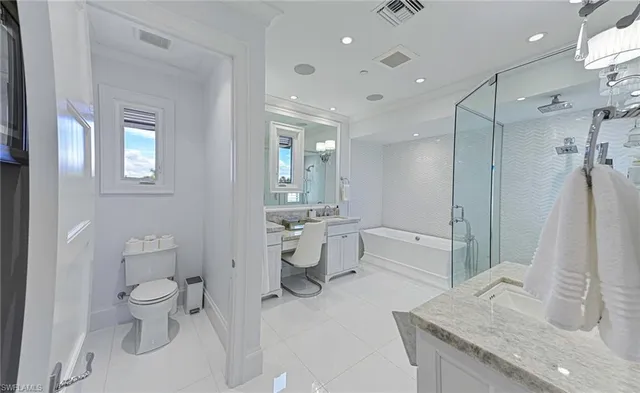 a bathroom with a granite countertop sink a toilet and shower