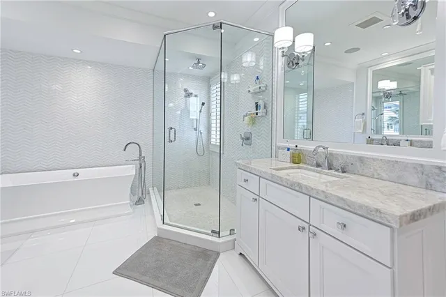 a bathroom with a granite countertop sink mirror and shower