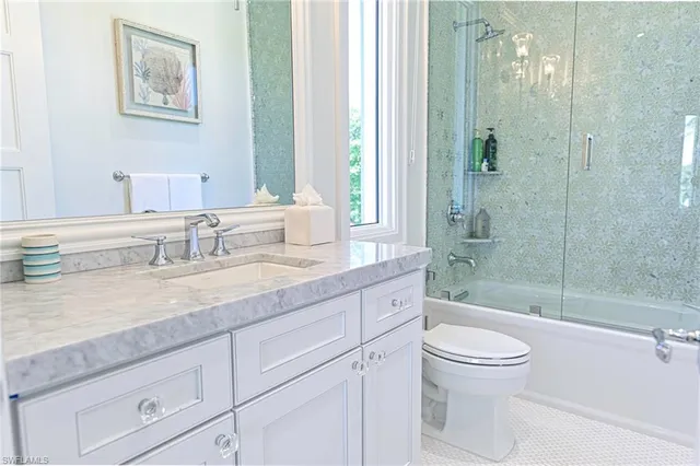 a bathroom with a granite countertop sink a toilet and shower