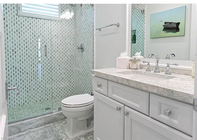 a bathroom with a granite countertop toilet sink and mirror