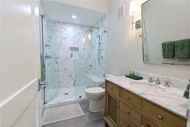 a bathroom with a granite countertop sink toilet and shower