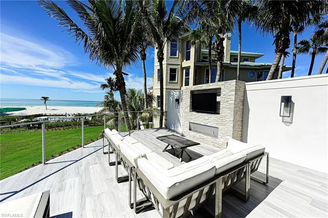 a view of a patio with table and chairs and potted plants with wooden floor and fence