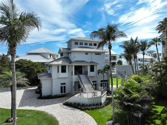 a front view of a house with a garden and trees