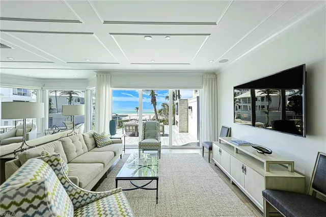 a large living room with stainless steel appliances furniture and a large window