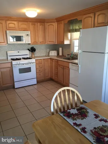a kitchen with a refrigerator and a stove top oven
