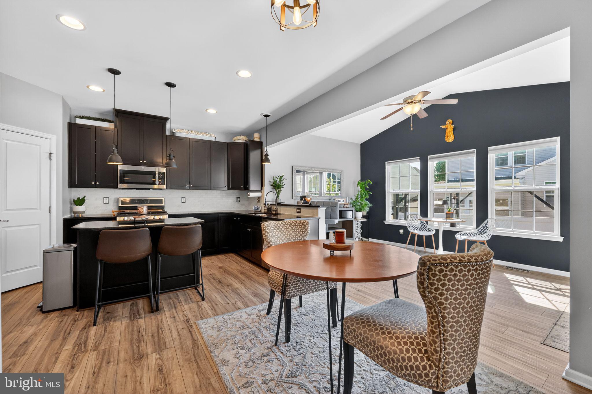 132 Redtail Hawk Circle Sewell, NJ 08080 - Photo 5 of 30 a kitchen with stainless steel appliances granite countertop a stove a refrigerator a kitchen island a dining table and chairs with wooden floor