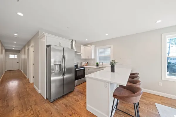 a kitchen with stainless steel appliances granite countertop a refrigerator and a stove top oven