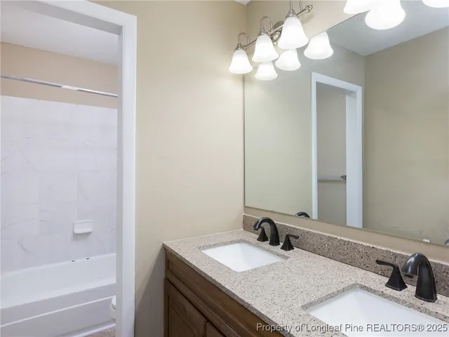 a bathroom with a granite countertop sink a mirror and a bathtub