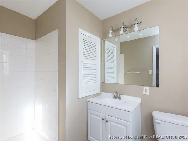 a bathroom with a sink a toilet and mirror