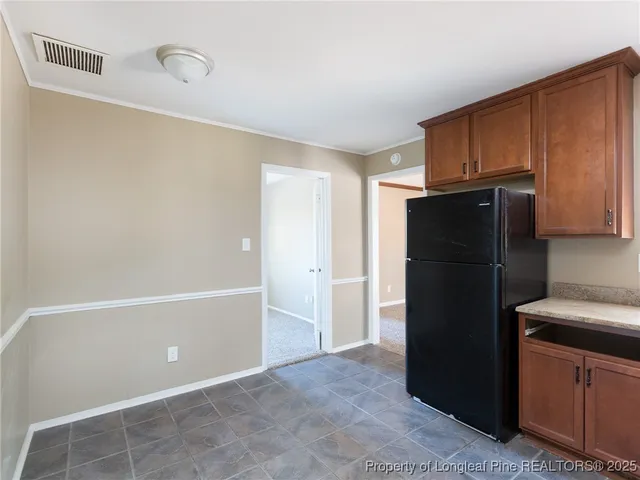 a kitchen with a refrigerator and cabinets