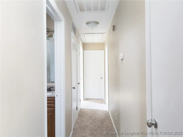 a view of a hallway with wooden floor and closet