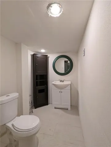 a bathroom with a sink a toilet and a mirror