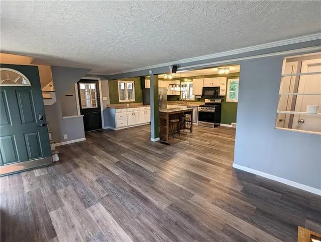 a view of a living room with hardwood floor and a window