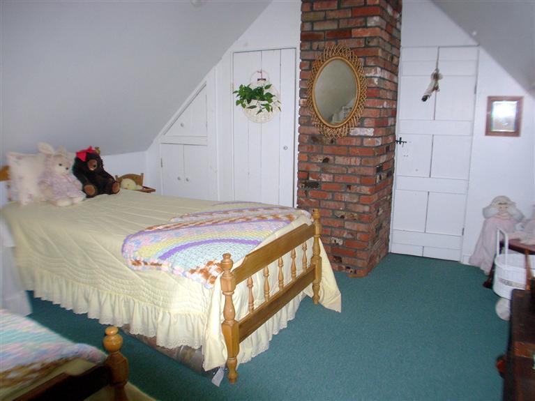 265 Chatham Road Harwich, MA 02645 - Photo 27 of 35 a bed sitting in a bedroom next to a window and a chandelier