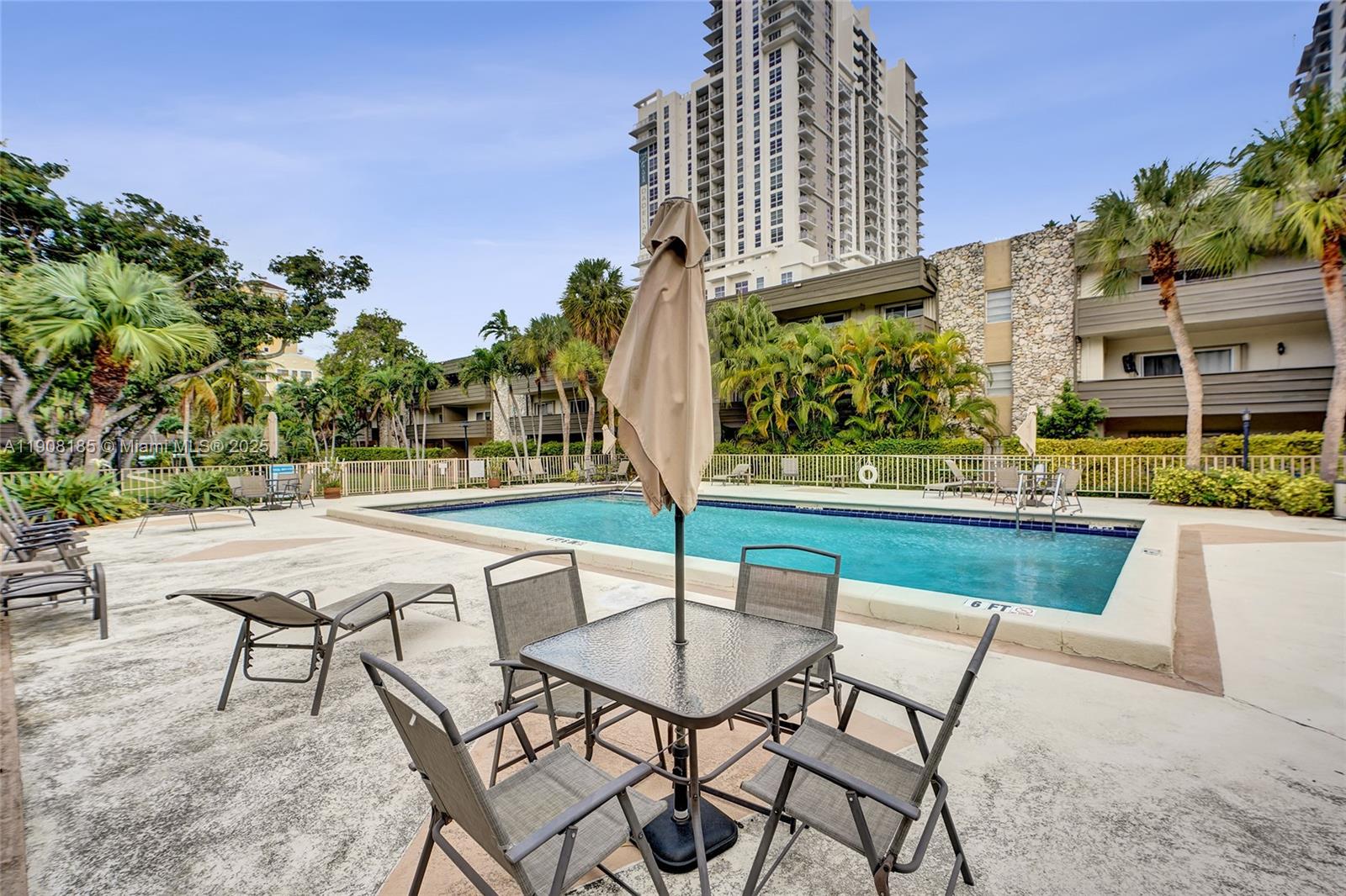 8335 Southwest 72nd Avenue, Unit 205D Miami, FL 33143 - Photo 15 of 19 a swimming pool with outdoor seating and yard in the back