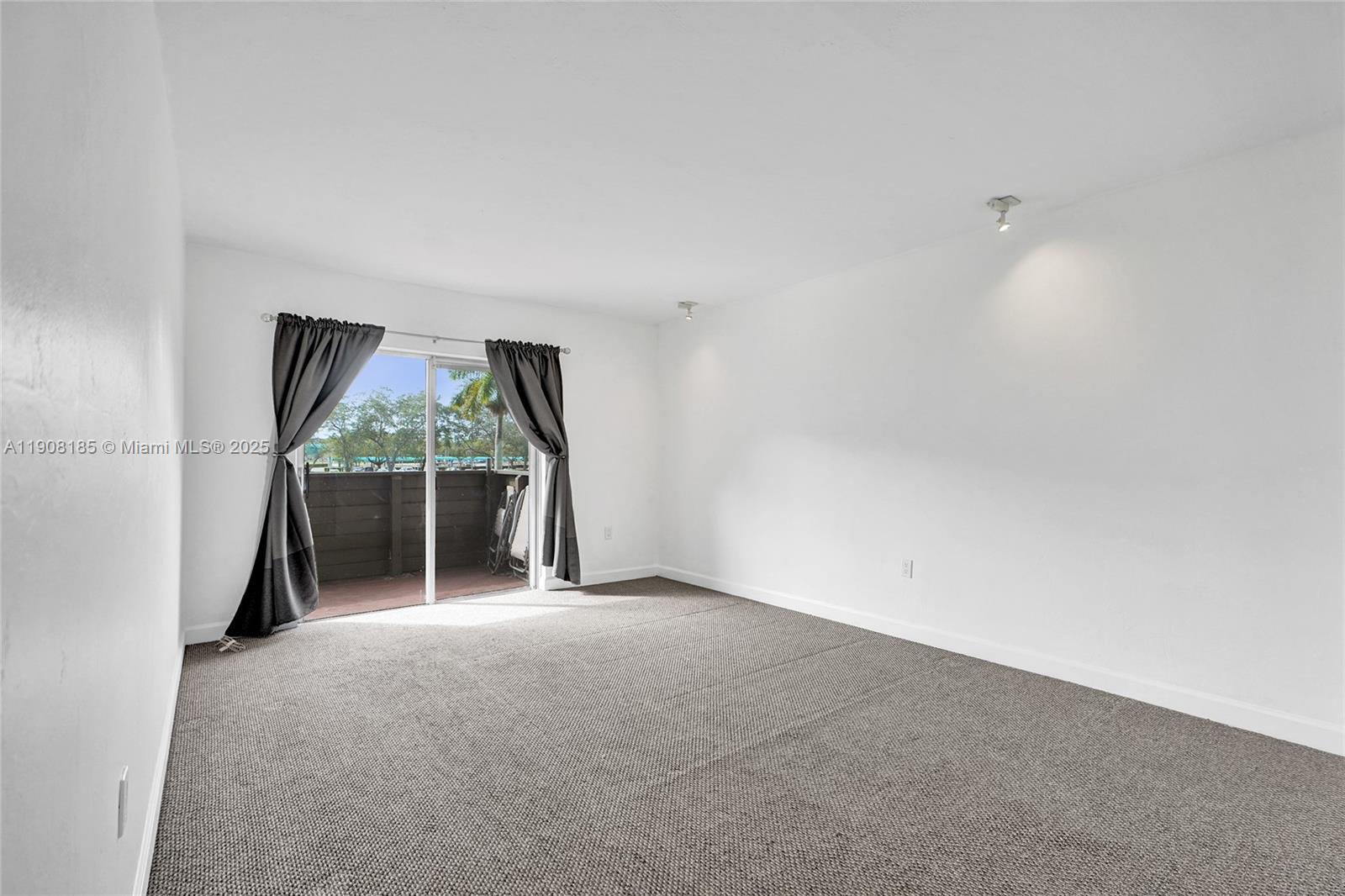 8335 Southwest 72nd Avenue, Unit 205D Miami, FL 33143 - Photo 6 of 19 an empty room with a fireplace and large window