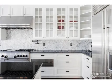 a view of kitchen with granite countertop white cabinets and stainless steel appliances